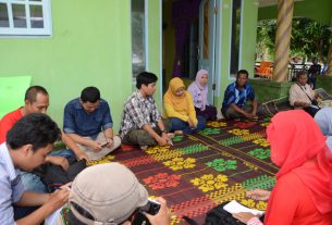 Photo caption: Workshop participants meet Tanjungleban Village Head Haji Atim (blue striped shirt second from right facing camera) on the front veranda of his house June 1 2014. (*)